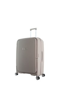 Hard-shell suitcase in beige with vertical ribbed texture, silver hardware, telescopic handle, and four spinner wheels for mobility.