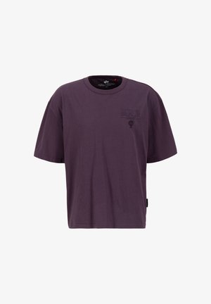 Camiseta de algodón morada con mangas cortas, que presenta un diseño impreso de "BERLÍN" en el frontal y una etiqueta en el lateral. Corte casual.