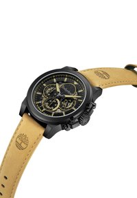 Orologio cronografo nero con quadrante nero e dettagli gialli. Presenta un cinturino in pelle marrone con logo impresso e dettagli di cucitura.