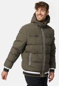 Olive green padded jacket with a hood, featuring zippered chest pockets, ribbed hem and cuffs, and contrasting white and black accents.