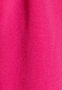 Jasně růžová tkanina s hladkým povrchem a jemnými sklady, rovnoměrně osvětlená, aby zvýraznila její jasnou barvu a jemný vzor tkaní.