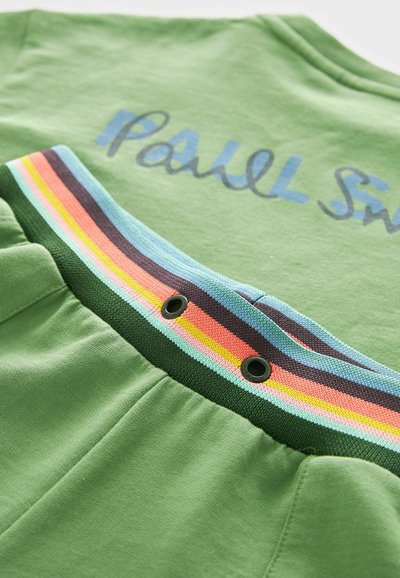 Zöld pamutruházat kék "Paul Smith" felirattal, színes csíkos elasztikus derékpánttal, amely fekete fém szemekkel állítható.