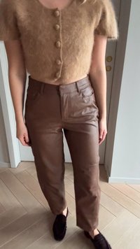 Brązowe, skórzane spodnie z wysokim stanem o dopasowanym kroju, z przednimi kieszeniami i gładką fakturą. Połączone z puszystym, beżowym, krótkim topem z guzikami.