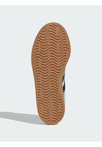 Podeszwa zewnętrzna z gumy z wzorem fal, w odcieniach brązu. Boczne elementy ozdobione jasnoniebieskimi i ciemnymi paskami dla dodatkowego efektu.