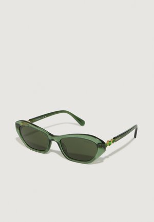 Ochelari de soare verzi cu o formă retro de tip cat-eye, rame transparente, lentile întunecate și accesorii aurii cu accente colorate pe temple.