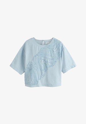 Hele sinine lühikeste varrukatega kõhuni lõigatud top, millel on ümar kaelus ja tekstuurse lainelise tikandi detail esiküljel ja vasakul õlal.