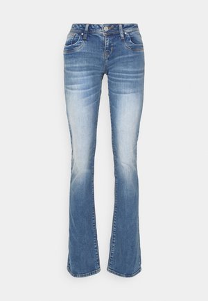 Light blue denim flared jeans with faded effect, five pockets, and metal button closure. The fabric features a soft texture and slight stretch.