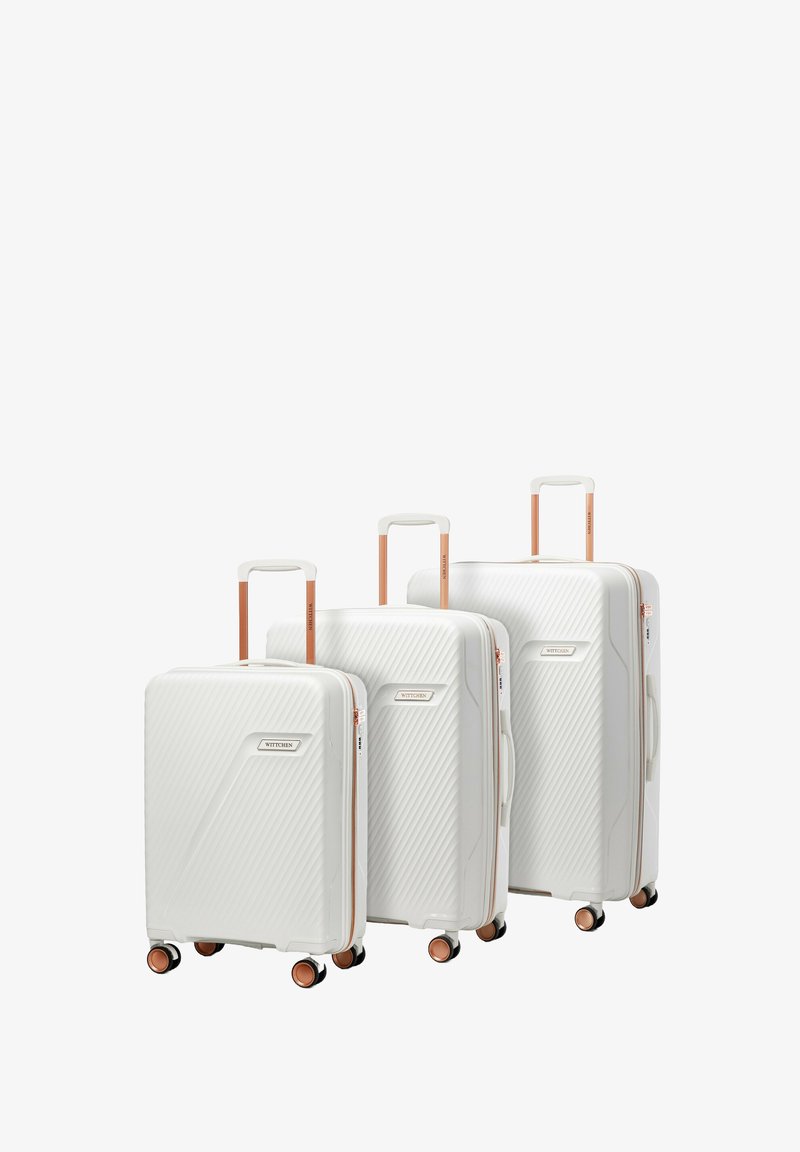 Drei weiße Hartschalenkoffer in unterschiedlichen Größen mit diagonalen Rillen, roségoldenen Akzenten und vier Spinner-Rädern.