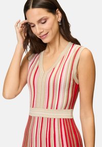 Knit sleeveless dress with a v-neck, featuring horizontal stripes in red, pink, and beige, textured fabric, and a fitted waist.