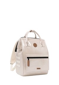 Hellbeige, glänzender Rucksack mit strukturiertem Design, ausgestattet mit einer vorderen Reißverschlusstasche, Logo-Patch und verstellbaren, gepolsterten Trägern.