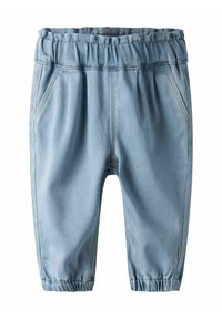 Lys blå denimbukser med elastisk midjebånd, sidelommer og innsnevrede mansjetter, med kontrastfarget søm langs sømmene.