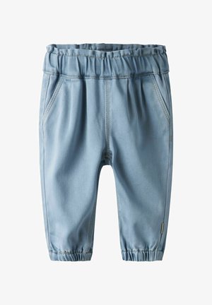 Pantalon en denim bleu clair avec taille élastique, poches latérales et bas resserrés, présentant des coutures contrastantes le long des coutures.