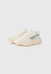Beige sneakers with light blue accents, a textured upper, rounded toe, and thick sole. Features laces and logo on tongue.
