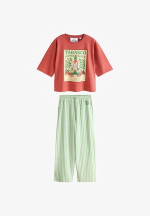 Tricou roșu scurt cu imprimeu vintage cu sticla Tabasco și pantaloni largi cu dungi verticale albe și verzi deschise, talie elastică.