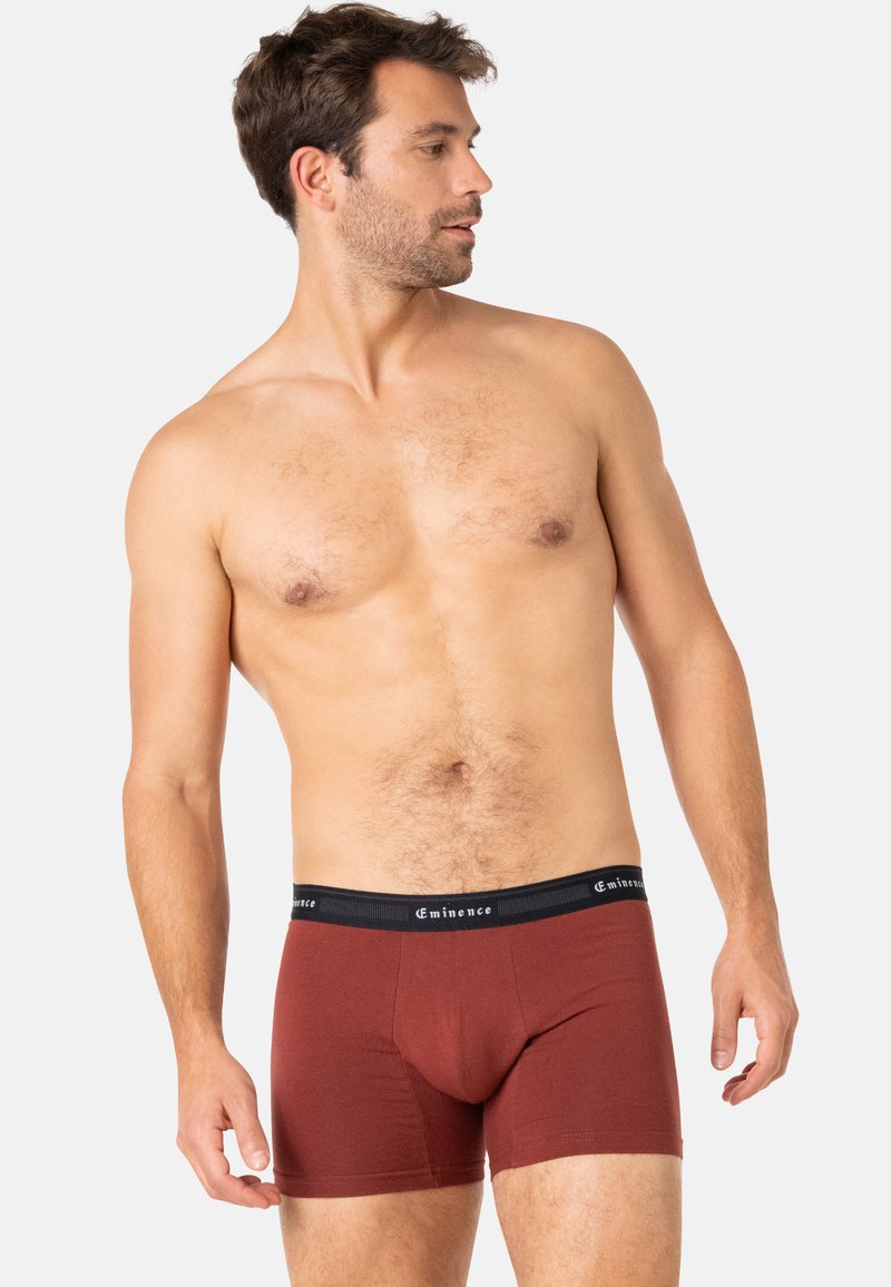 Boxers couleur bourgogne en coton doux avec une taille noire portant le nom de la marque "Eminence" en blanc. Design ajusté.