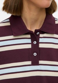 Poloshirt met korte mouwen in bordeauxrood met horizontale strepen in crème en lichtblauw, voorzien van een tweeknopsplooi en een geribbelde kraag.