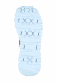 Weiße Gummisohle mit strukturierten Grip-Mustern, einschließlich Kreisen und Linien, die für Traktion sorgen. Hell gefärbt mit einer glatten Oberfläche.