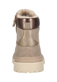 Bottines beiges avec un accent en bronze métallique et une doublure douce en fausse fourrure. Présentent une fermeture éclair à l'arrière et une semelle en caoutchouc texturée.