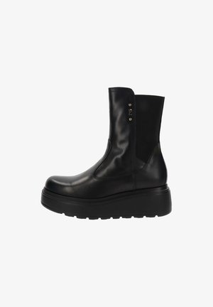 Bottines en cuir noir avec un design épuré, des panneaux latéraux élastiques et une semelle en caoutchouc épaisse pour plus de hauteur et de confort.