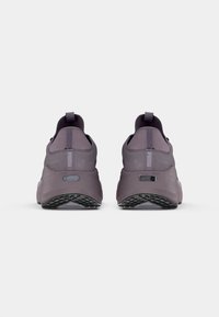 Pantofi sport violeți cu un upper texturat, guler căptușit și accente reflectorizante. Prezintă o talpă căptușită și o talpă texturată pentru aderență.