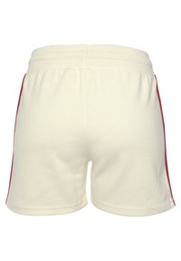 Crèmekleurige shorts met zijrode strepen, gemaakt van zachte stof. Beschikt over een elastische tailleband en een comfortabele pasvorm. Eenvoudige achterkant.