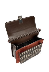 Brązowa skórzana torba z magnetycznym zapięciem, wewnętrzną kieszenią na suwak oraz przednią klapką z wzorem w paski w kolorze czarnym i kremowym.