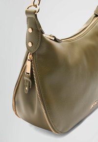 Olijf groen leren handtas met een ronde vorm, gouden accenten en een opvallende ritsdetails langs de zijkant. Geweven oppervlak.