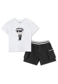 Witte katoenen t-shirt met grafisch ontwerp van een personage dat een zonnebril en een vizier draagt, gecombineerd met zwarte shorts met cargozakken en een gestreepte tailleband.