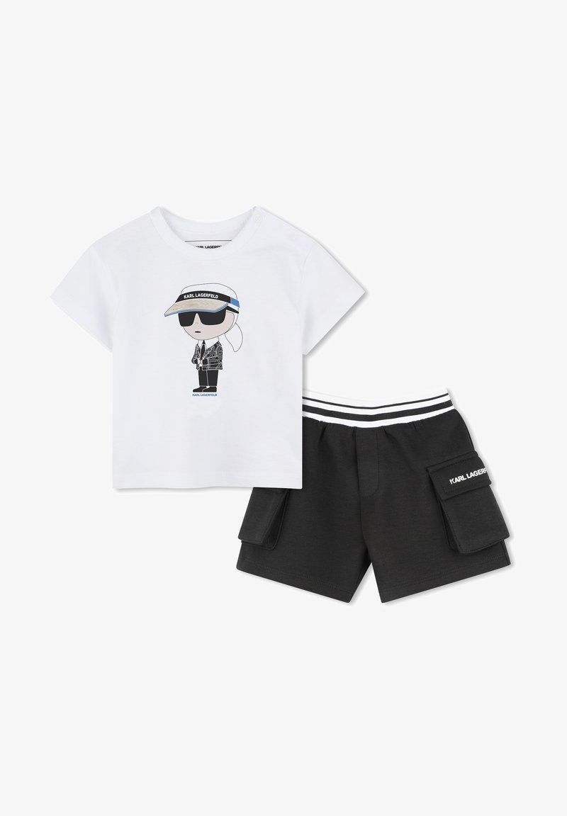 Witte katoenen t-shirt met grafisch ontwerp van een personage dat een zonnebril en een vizier draagt, gecombineerd met zwarte shorts met cargozakken en een gestreepte tailleband.