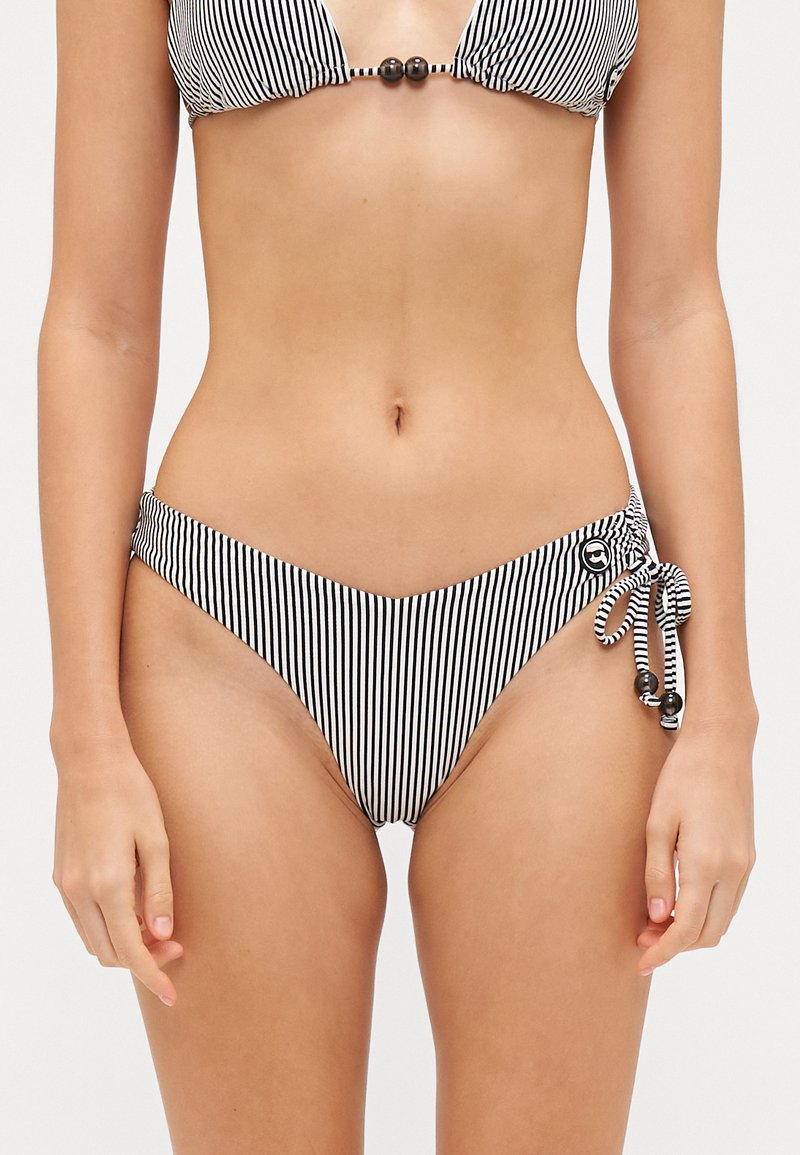 Čierny a biely pruhovaný bikiny top s trojuholníkovými pohárikmi a korálikovým doplnkom. Zodpovedajúce nízko zvýšené bikiny spodky so bočnými viazaniami a detailom loga.