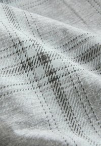 Sivá látka s jemným károvaným vzorom v rôznych odtieňoch šedej a čiernych líniách. Mäkká textúra, ľahká a s mierne melírovaným vzhľadom.