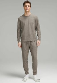 Harmaa pitkähihaisen paidan ja vastaavien kapenevien housujen asu, joka on valmistettu pehmeästä kankaasta. Sisältää nyöri vyötärön ja vastakohtaiset valkoiset liukuvarvastossut.