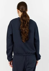 Navy blue sweatshirt with a relaxed fit, ribbed cuffs, and a small logo on the back. Made from a soft cotton-blend material.