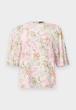 Blouse fleurie à manches larges trois-quarts et coupe ample, présentant des motifs floraux doux en rose, vert et orange sur fond blanc.