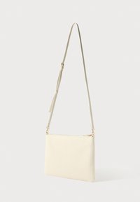 Krém bőr keresztpántos táska, sima textúrával, téglalap alakú, állítható pánttal és arany színű díszítésekkel.