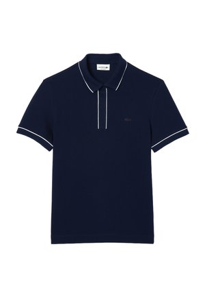 Granatowy polo z kołnierzykiem, białym obramowaniem na kołnierzyku i rękawach oraz małym haftowanym logo na piersi. Materiał bawełniany.