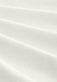 Țesătură de bumbac alb cu o textură netedă, prezentând pliuri delicate și o strălucire subtilă, care reflectă lumina pe suprafață.