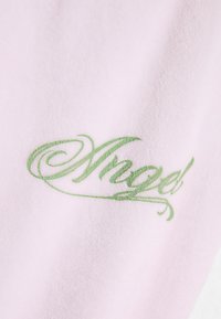 Világos rózsaszín anyag, zöld díszített "Angel" (Angyal) írott betűkkel, puha tapintással és sima felülettel.