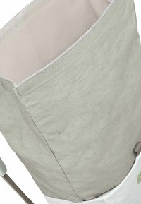 Borsa di stoccaggio in tessuto grigio con base bianca, forma cilindrica e design semplice. Presenta un interno liscio e una maniglia robusta.