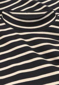 Zwart en crèmekleurig gestreept rib t-shirt met een hoge hals, voorzien van horizontale strepen van verschillende breedtes op een gestructureerde stof.