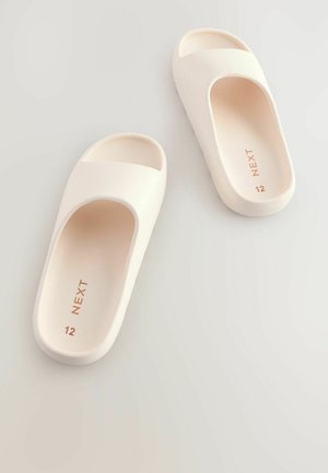 Sandale albe slip-on, cu vârf și toc deschis, având un finisaj neted, mat. Mărimea 12, cu "NEXT" debossat pe branț.