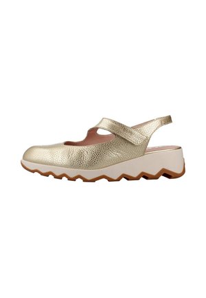Zapato de mujer tipo slingback de cuero dorado texturizado con una correa de velcro y suela gruesa blanca en zigzag.