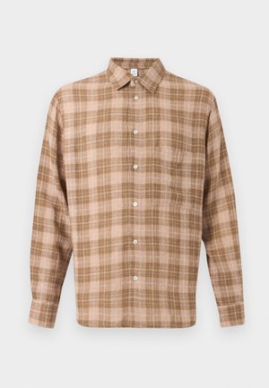 Barna és bézs kockás mintájú, hosszú ujjú, gombos ing hegyes gallérral és elülső zsebbel, egyszínű háttéren.