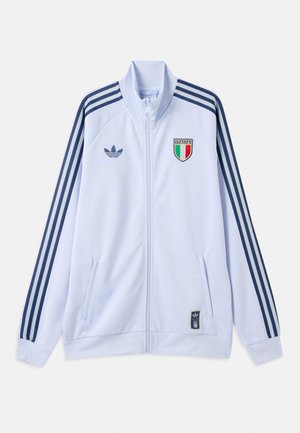 Hvit Adidas treningsjakke med marineblå striper på ermene, Italia-skjoldlogo på brystet, og glidelås foran med lommer.