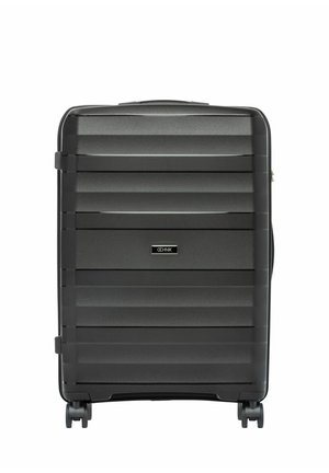 Czarna walizka z twardą skorupą z poziomymi żłobieniami, czterema obrotowymi kółkami oraz centralną etykietą marki na przednim panelu.