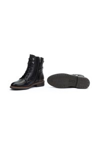 Bottines en cuir noir avec une finition lisse, lacets à l'avant, fermeture éclair sur le côté et une semelle en caoutchouc texturée avec un motif de traction.
