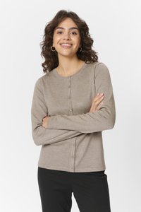 Lichtbruine cardigan met een ronde halslijn, knoopsluiting en lange mouwen, gemaakt van een zachte stof, gecombineerd met zwarte broek.