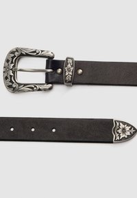 Cinturón de cuero negro con una hebilla plateada grabada con motivos florales, herrajes plateados a juego y un extremo decorativo. Presenta múltiples agujeros de ajuste.