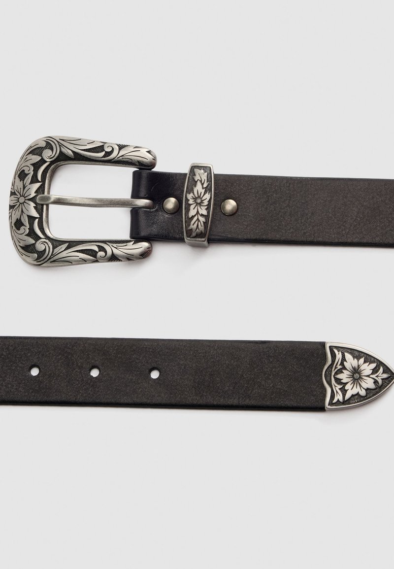 Cinturón de cuero negro con una hebilla plateada grabada con motivos florales, herrajes plateados a juego y un extremo decorativo. Presenta múltiples agujeros de ajuste.