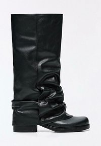 Črne usnjene škornje do kolen s sproščenim dizajnom, z zaponkami na pritrdilne gumbe in zaobljenim sprednjim delom. Gladek tekstura in ravna podplat.